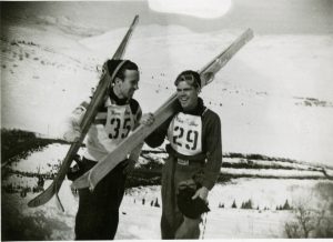 Gordy Despain (#35) and Mel Fletcher (#29) standing at the top of Ecker Hill at the 1948-49 Utah Centennial ski jump meet.